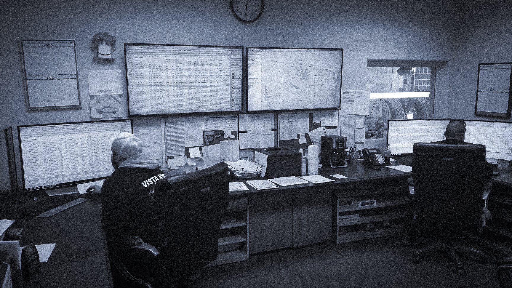 Heavy equipment dispatching team manages work on multiple screens.